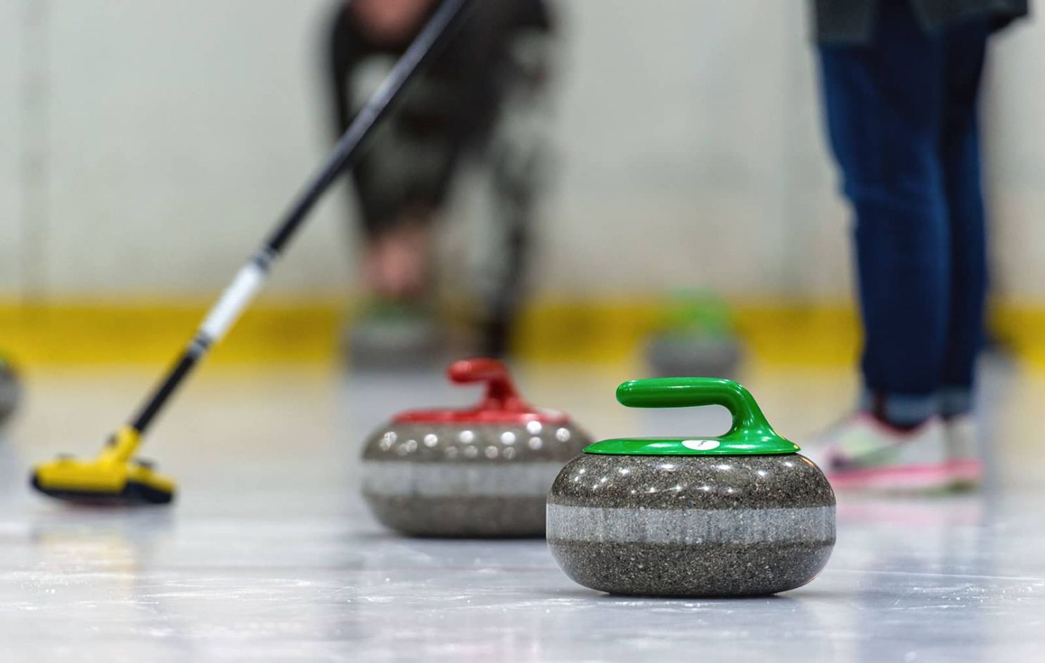 ice curling showing stones and sweeping