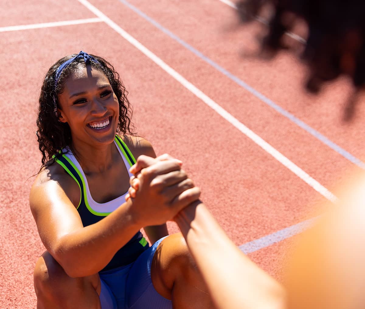 Track and Field athlete being helped to her feet